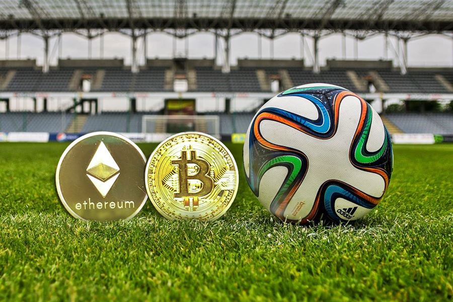 Krypto-Coins mit einem Ball auf einem Fußballfeld
